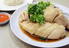 Delicious Singaporean Hainanese chicken rice with tender poached chicken, herbs, and flavorful sauce.